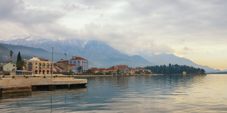 Beautiful Mediterranean landscape on cloudy winter day. Montenegro, embankment of Tivat city and snow-capped peaks of Lovcen mountainのeditorial素材