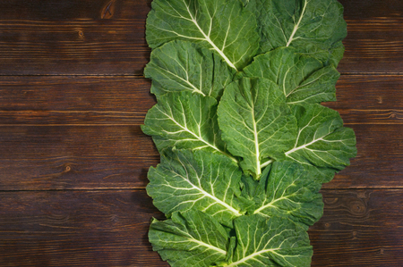 Rastan ( Collard greens, collards ) - popular leafy vegetables in Balkan cuisine. Dark rustic background, flat lay, free space for textの写真素材