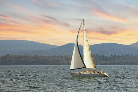 Sailboat sails  near shore of Bay of Kotor. Montenegro, Adriatic Sea. Travel concept