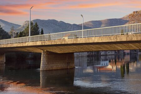 Bridge across river. Bosnia and Herzegovina, Republika Srpska, Trebinje city. View of Ivo Andric bridge across Trebisnjica river on winter eveningの写真素材