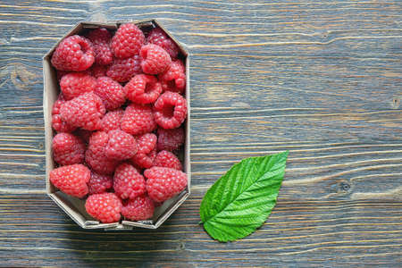 Red-fruited raspberries from market.  Fresh ripe raspberries in cardboard box on rustic table. Flat lay. Free space for textの写真素材