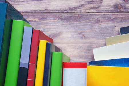 Different multi-colored books on rustic table. Copy spaceの写真素材