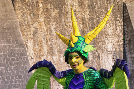 Kotor / Montenegro - March 03 2019: Traditional Winter Kotor Carnival.  Participant of Carnival in costume of dragon against ancient walls of Old Town of Kotorのeditorial素材
