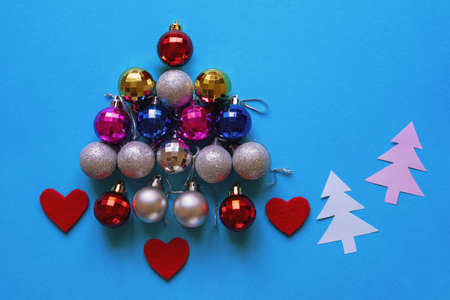 Bright multi-colored Christmas balls in the form of a Christmas tree. Flat lay, free space for textの写真素材