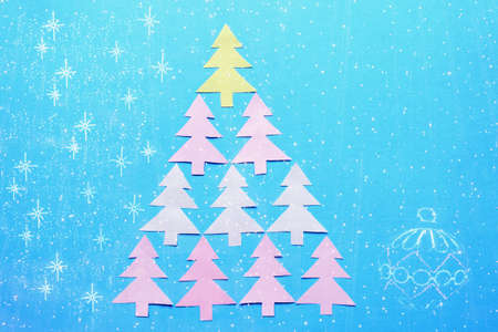 Paper fir-trees in the form of Christmas tree and bright festoon illumination - double exposure....