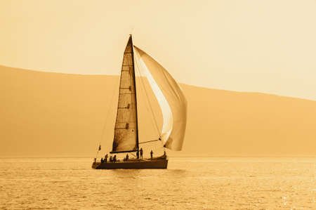 Silhouette of sailing boat on water, color tintingの写真素材