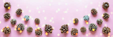 Pine cones on pink background and bokeh lights - double exposure. Flat lay, copy spaceの写真素材