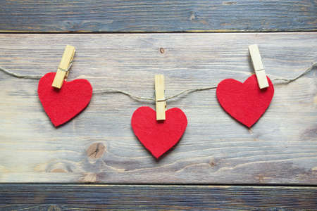 Handmade  hearts from red felt pinned on rope. Rustic background. Flat lay, free space for textの写真素材
