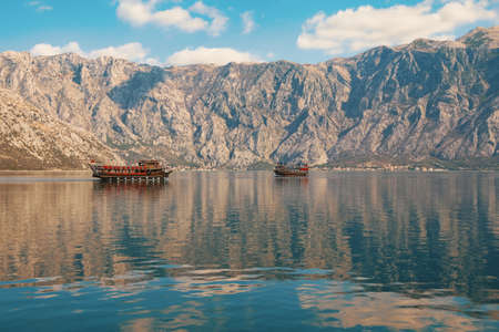 Winter Mediterranean landscape. Montenegro, Adriatic Sea. Beautiful view of Kotor Bay. Mountains, clouds and pleasure boats are reflected in calm waterの写真素材