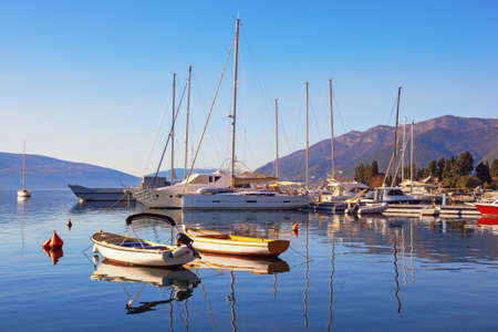 Sunny winter Mediterranean landscape. Yachts and fishing boats on the water. Bay of Kotor (Adriatic Sea), Tivat, Montenegroの写真素材