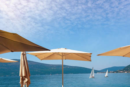 Vacation concept. Sun umbrellas against blue sky. Montenegro, Adriatic Sea. View of Kotor Bay near Tivat cityの写真素材
