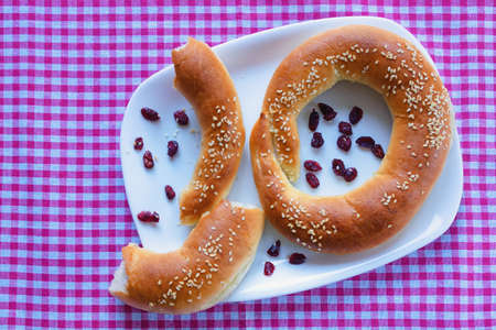 Tasty homemade bagels with lingonberries and sesame seedsの写真素材