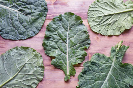 Leaves of rastan ( Collard greens, collards )   - popular leafy vegetables in Balkan cuisine. Rustic background. Flat layの写真素材