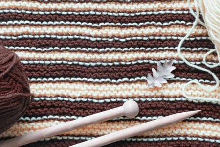 Striped white and brown background, homemade wool knitted texture with knitting needles. Hobby and knitting conceptsの写真素材
