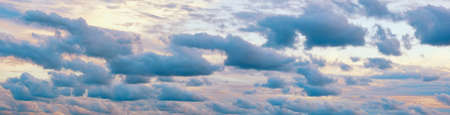 Beautiful row of blue clouds against sky at sunset. Cumulus clouds formationの写真素材
