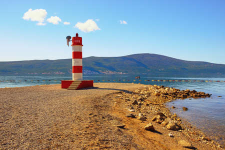 Sunny autumn day, beautiful Mediterranean landscape.  Montenegro. Coast of Bay of Kotor near Tivat city. Deserted pebble beach with beaconの写真素材