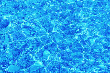 Abstract natural texture. Shallow water, stone beach. Blue color toningの写真素材