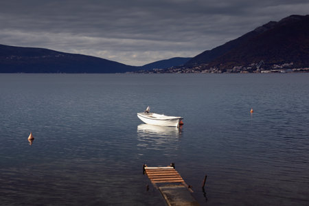 Cloudy landscape  with fishing boat on water. Montenegro, Adriatic Sea, Kotor Bayの写真素材