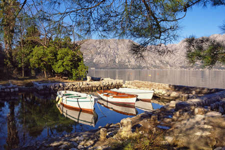 Sunny winter Mediterranean landscape. Montenegro, Adriatic Sea. View of  Kotor Bay. Small harbor for fishing boats near Prcanj townの写真素材
