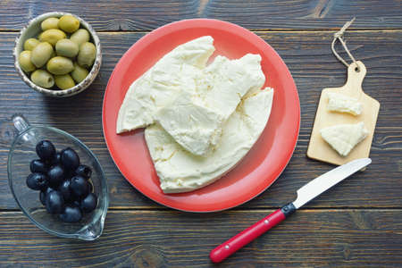 Balkan cuisine. Montenegro. Pljevaljski cheese  - local soft white cheese traditionally produced from sheeps milk. Flat lay, dark rustic backgroundの写真素材