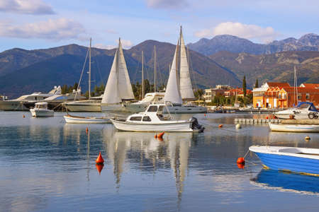 Winter Mediterranean landscape with sailboats and fishing boats on water. Montenegro, view of Kotor Bay near Tivat cityの写真素材