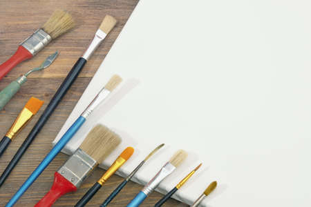 Different paintbrushes and white canvas. Free space for text or pictureの写真素材