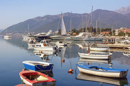 Beautiful misty Mediterranean landscape with fishing boats on water. Montenegro, Adriatic Sea, view of Kotor Bay near Tivat cityの写真素材