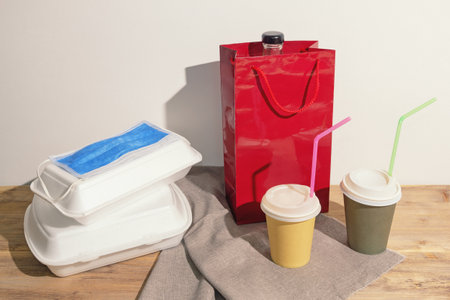 Food delivery. Various takeout containers and face protective mask on rustic table. Copy spaceの写真素材