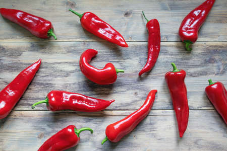 Red sweet peppers on rustic background, flat layの写真素材