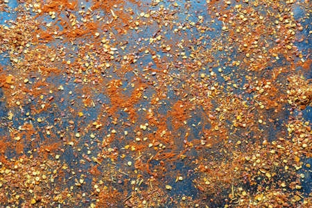 Hot background. Crushed hot paprika scattered on black metal surfaceの写真素材