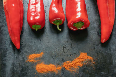 Bright red sweet peppers on dark metal background. Free space for textの写真素材