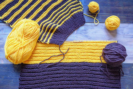 Unfinished knitting, balls of wool and knitting  needles on rustic tableの写真素材