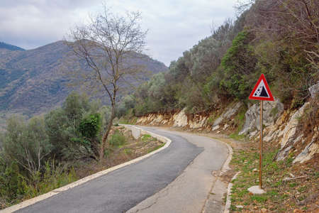 Balkan road trip. Old country road with a sign of falling stones. Montenegroの写真素材