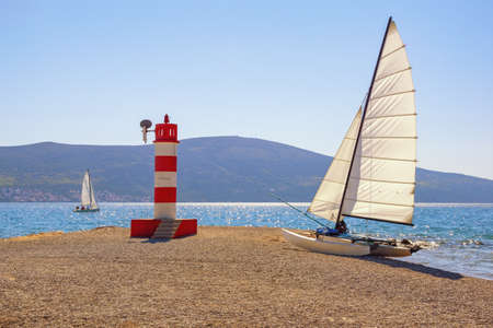 Summer beach vacations and recreation concept. Beautiful  sunny Mediterranean landscape.  Montenegro, Adriatic Sea. Coast of Kotor Bay near Tivat city, sailboats with white sailsの写真素材