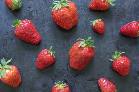 Red sweet strawberry on black metallic background, flat layの写真素材