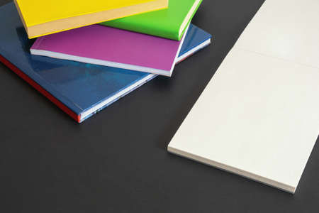 School concept. Colorful  books  and open sketchbook on dark background. Free space for textの写真素材