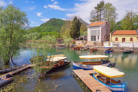 Montenegro. National Park Lake Skadar. Virpazar village  on sunny spring day. Tourist boats on riverの写真素材