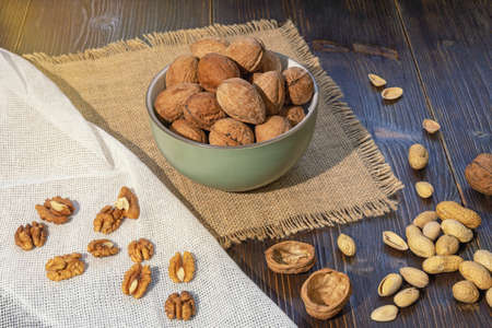 Nuts. Whole walnuts and kernels on dark rustic tableの写真素材