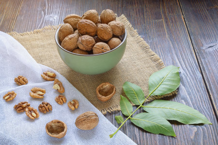 Whole walnuts and kernels on dark rustic table.  Leaves of walnut treeの写真素材