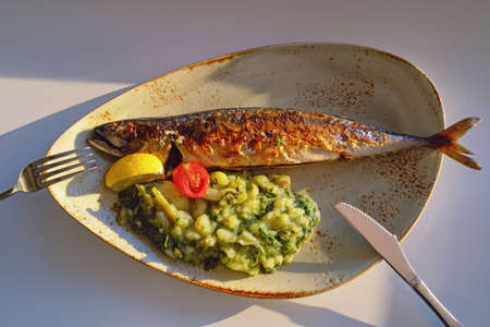 Balkan cuisine. Grilled fish ( mackerel ) with green leafy vegetables. Flat lay, copy spaceの写真素材