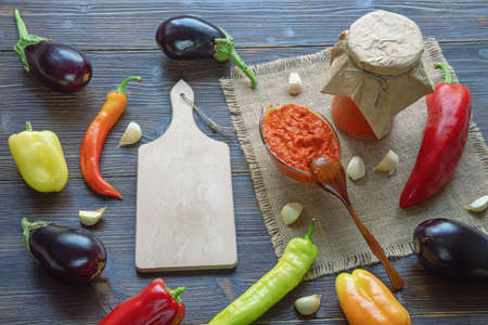 Balkan cuisine. Ajvar, delicious product of pepper, eggplants, garlic - on dark rustic tableの写真素材