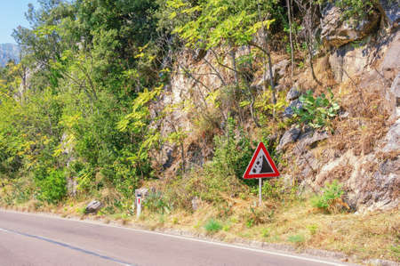Balkan road trip. Mountainside and road with a sign of falling stones. Montenegro, Perastの写真素材