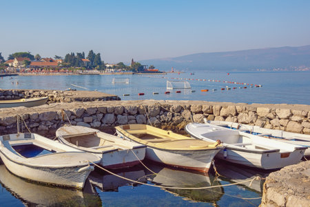 Beautiful Mediterranean landscape on sunny summer day. Montenegro, Adriatic Sea. Coast of Bay of Kotor near Tivat city. Stone jetty for fishing boatsの写真素材