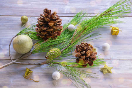 Green branch of pine tree, pine cones and Christmas decorations  on rustic table. Bokehの写真素材
