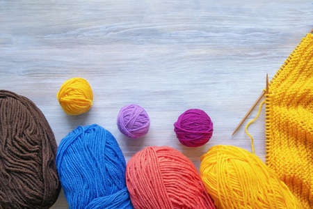 Hobbies and knitting concept. Colorful balls of wool and  knitting needles on rustic table. Free space for textの写真素材
