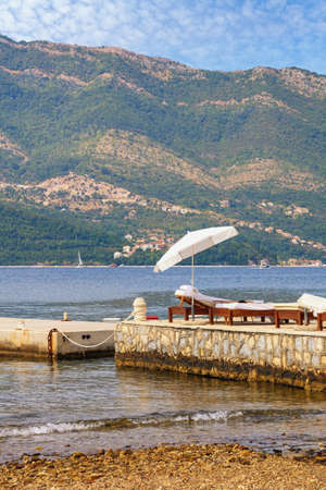 Autumn beach vacation concepts.  Beach umbrella on coast of Kotor Bay. Montenegro,  Adriatic Seaの写真素材