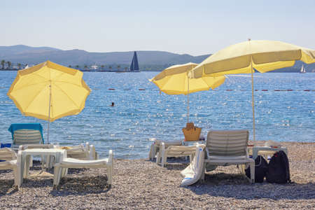 Autumn beach vacation concepts.  Beach umbrellas on coast on sunny day. Montenegro,  Adriatic Sea, Kotor Bay near Tivat cityの写真素材