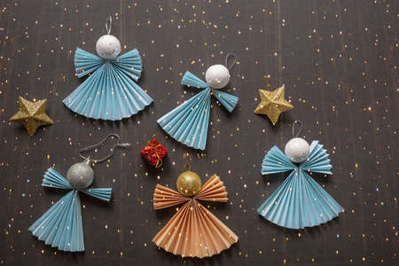 Christmas decorations. Paper Christmas angels on dark background, handmade . Flat lay, free space for textの写真素材