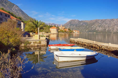 Beautiful autumn Mediterranean landscape on sunny day. Fishing boats in small harbour. Montenegro, Adriatic Sea. View of Kotor Bay and Prcanj townの写真素材