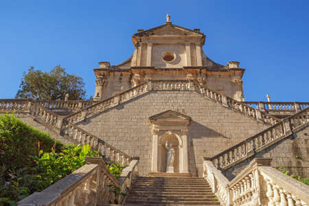 Religious architecture.  Venetian baroque. Montenegro, Prcanj town ( Kotor ). View of ancient Catholic church of Birth of Our Lady on sunny autumn dayの写真素材